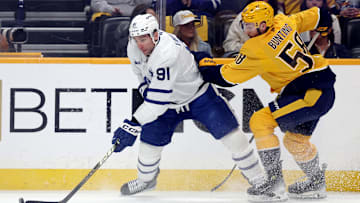 Mar 22, 2025; Nashville, Tennessee, USA; Toronto Maple Leafs center John Tavares (91) moves the puck past Nashville Predators defenseman Roman Josi (59) during the first period of their game at Bridgestone Arena. Mandatory Credit: Alan Poizner-Imagn Images