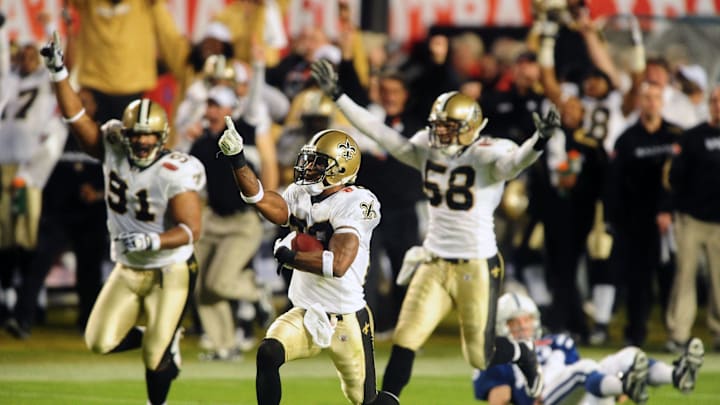 Feb 7, 2010; Miami, FL, USA; New Orleans Saints cornerback Tracy Porter (22) celebrates as he returns an interception for a touchdown as Indianapolis Colts quarterback Peyton Manning looks on from the ground during the fourth quarter of Super Bowl XLIV at Sun Life Stadium. Mandatory Credit: Mark J. Rebilas-Imagn Images