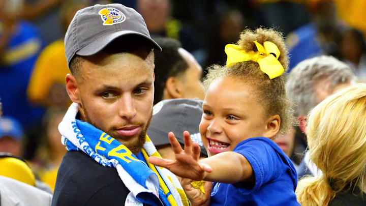 Golden State Warriors guard Stephen Curry celebrates with his daughter Riley Curry after beating the Cleveland Cavaliers in Game 5 of the 2017 NBA Finals.