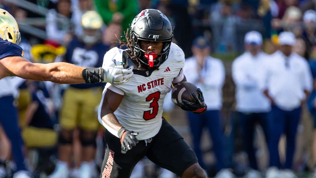 NC State Wolfpack running back Hollywood Smothers tries to break a tackle attempt by Notre Dame Fighting Irish linebacker Joshua Burnham.