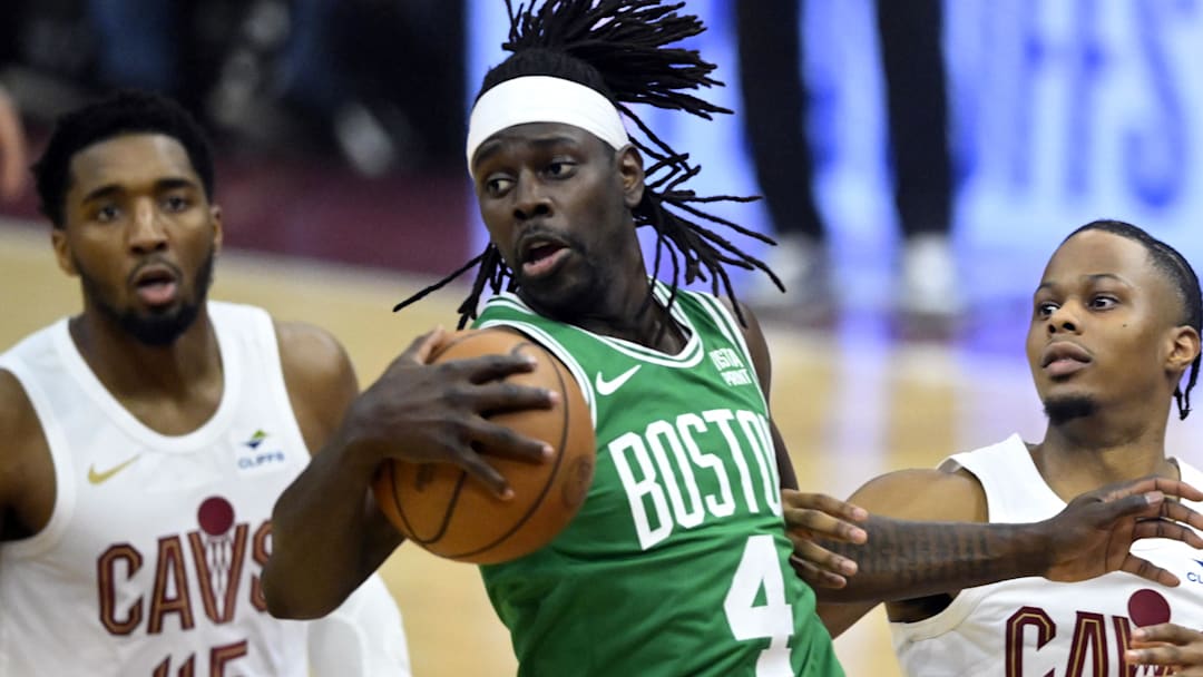 May 11, 2024; Cleveland, Ohio, USA; Boston Celtics guard Jrue Holiday (4) rebounds against Cleveland Cavaliers guard Donovan Mitchell (45) and forward Isaac Okoro (35) in the first quarter of game three of the second round of the 2024 NBA playoffs at Rocket Mortgage FieldHouse. Mandatory Credit: David Richard-Imagn Images