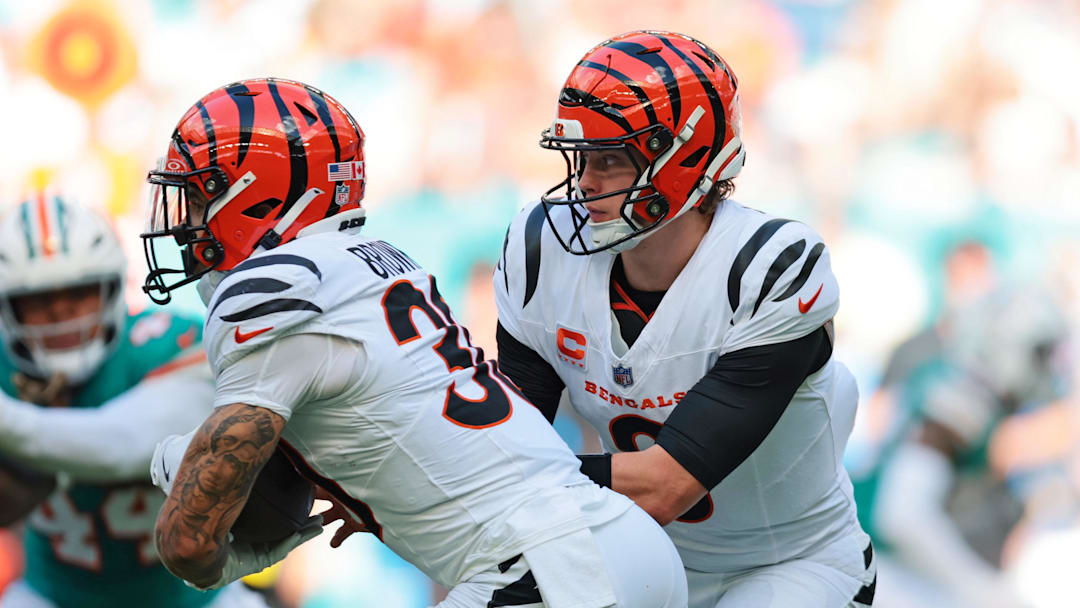 Dec 21, 2025; Miami Gardens, Florida, USA; Cincinnati Bengals quarterback Joe Burrow (9) hands off the ball to Cincinnati Bengals running back Chase Brown (30) during the first quarter against the Miami Dolphins at Hard Rock Stadium. Mandatory Credit: Sam Navarro-Imagn Images