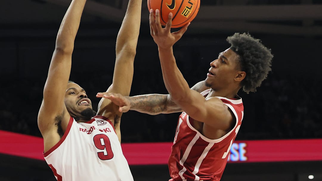 Oklahoma Sooners forward Jalen Moore (14) shoots in the first half as Arkansas Razorbacks forward Jonas Aidoo (9) defends at Bud Walton Arena.