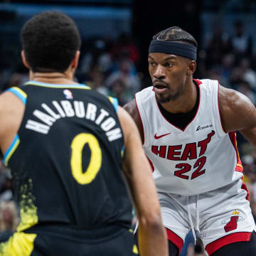 Apr 7, 2024; Indianapolis, Indiana, USA;  Miami Heat forward Jimmy Butler (22) dribbles the ball while  Indiana Pacers guard Tyrese Haliburton (0) defends in the second half at Gainbridge Fieldhouse. Mandatory Credit: Trevor Ruszkowski-USA TODAY Sports