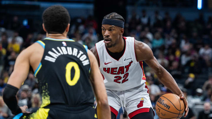 Apr 7, 2024; Indianapolis, Indiana, USA;  Miami Heat forward Jimmy Butler (22) dribbles the ball while  Indiana Pacers guard Tyrese Haliburton (0) defends in the second half at Gainbridge Fieldhouse. Mandatory Credit: Trevor Ruszkowski-USA TODAY Sports