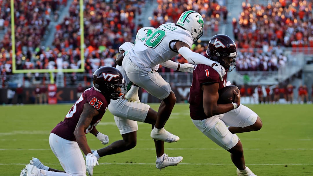 Sep 7, 2024; Blacksburg, Virginia, USA; Virginia Tech Hokies quarterback Kyron Drones (1) run for a touchdown during the third quarter against Marshall Thundering Herd cornerback Jacobie Henderson (10) at Lane Stadium. Mandatory Credit: Peter Casey-Imagn Images