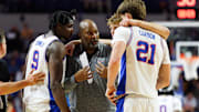 Florida Gators associate head coach Carlin Hartman talks with center Rueben Chinyelu (9), forward Thomas Haugh (10) and forward Alex Condon (21) during a timeout against the North Florida Ospreys.