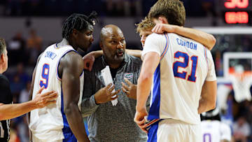 Florida Gators associate head coach Carlin Hartman talks with center Rueben Chinyelu (9), forward Thomas Haugh (10) and forward Alex Condon (21) during a timeout against the North Florida Ospreys.