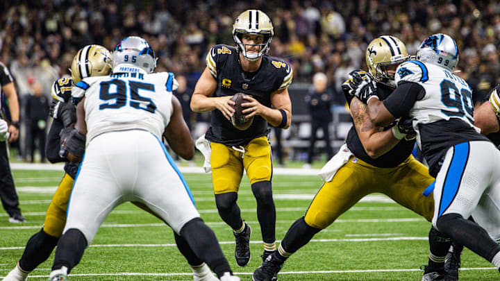 Dec 10, 2023; New Orleans, Louisiana, USA; New Orleans Saints quarterback Derek Carr (4) looks to pass against Carolina Panthers defensive tackle Derrick Brown (95) during the second half at the Caesars Superdome. Mandatory Credit: Stephen Lew-Imagn Images