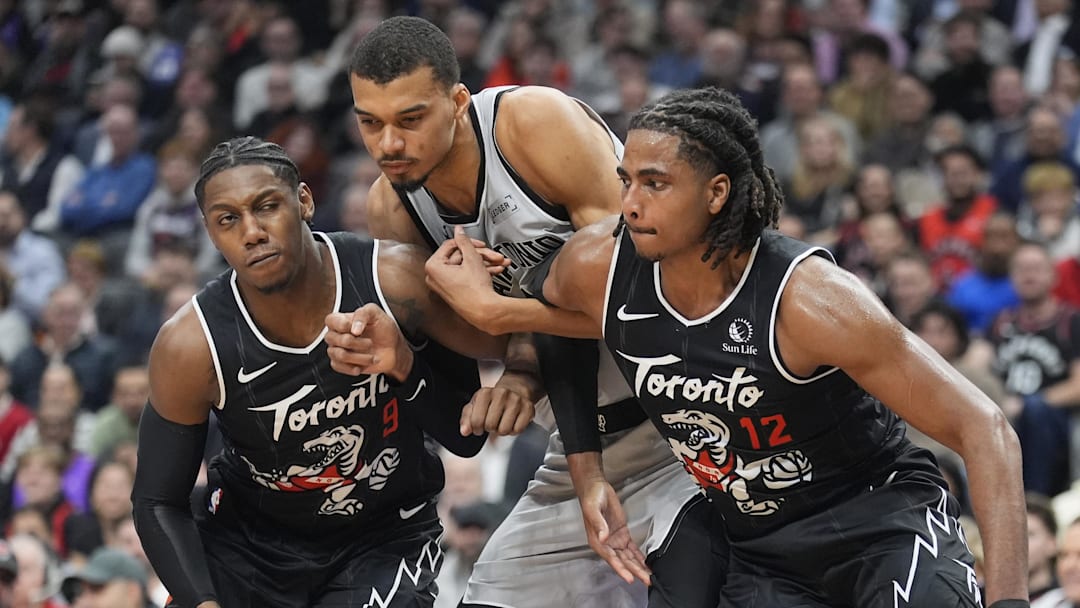 Feb 25, 2026; Toronto, Ontario, CAN; Toronto Raptors forward R.J. Barrett (9) and forward Collin Murray-Boyles (12) block out San Antonio Spurs center Victor Wembanyama (1) during the first half at Scotiabank Arena.