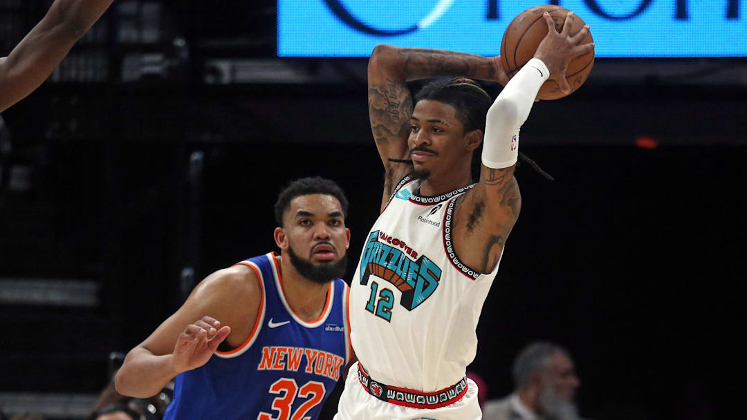 Feb 28, 2025; Memphis, Tennessee, USA; Memphis Grizzlies guard Ja Morant (12) passes the ball as New York Knicks center Karl-Anthony Towns (32) defends during the second quarter at FedExForum. Mandatory Credit: Petre Thomas-Imagn Images
