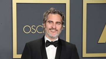 Joaquin Phoenix poses with his award for Best Actor