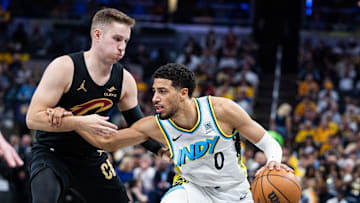 May 11, 2025; Indianapolis, Indiana, USA; Indiana Pacers guard Tyrese Haliburton (0) dribbles the ball while Cleveland Cavaliers guard Sam Merrill (5) defends during game four of the second round for the 2025 NBA Playoffs at Gainbridge Fieldhouse. Mandatory Credit: Trevor Ruszkowski-Imagn Images