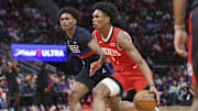 Houston Rockets forward Amen Thompson controls the ball as Detroit Pistons forward Ausar Thompson defends.