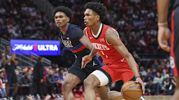 Houston Rockets forward Amen Thompson controls the ball as Detroit Pistons forward Ausar Thompson defends.