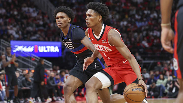 Houston Rockets forward Amen Thompson controls the ball as Detroit Pistons forward Ausar Thompson defends.