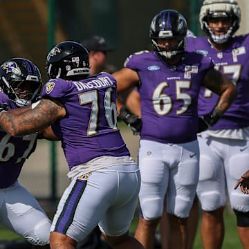 Baltimore Ravens offensive linemen Corey Bullock (67) and Darrian Dalcourt (76) run through a drill during a joint practice with the Green Bay Packers.