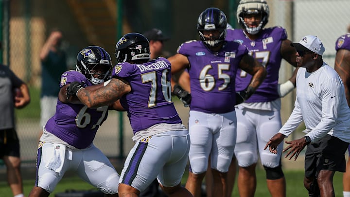 Baltimore Ravens offensive linemen Corey Bullock (67) and Darrian Dalcourt (76) run through a drill during a joint practice with the Green Bay Packers.