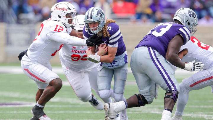 Oct 28, 2023; Manhattan, Kansas, USA; Kansas State Wildcats quarterback Avery Johnson (5) is tackled by Houston Cougars defensive lineman David Ugwoegbu (12) during the fourth quarter at Bill Snyder Family Football Stadium. Mandatory Credit: Scott Sewell-USA TODAY Sports