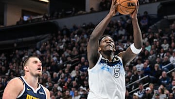 Jan 25, 2025; Minneapolis, Minnesota, USA; Minnesota Timberwolves guard Anthony Edwards (5) goes to the basket for a slam dunk over Denver Nuggets center Nikola Jokic (15) during the third quarter at Target Center. Mandatory Credit: Jeffrey Becker-Imagn Images
