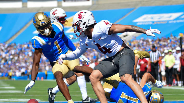 Oct 7, 2023; Pasadena, California, USA; UCLA Bruins linebacker Ale Kaho (1) misses catching a pass against the defense of Washington State Cougars defensive back Kapena Gushiken (4) during the first half at Rose Bowl. Mandatory Credit: Gary A. Vasquez-USA TODAY Sports