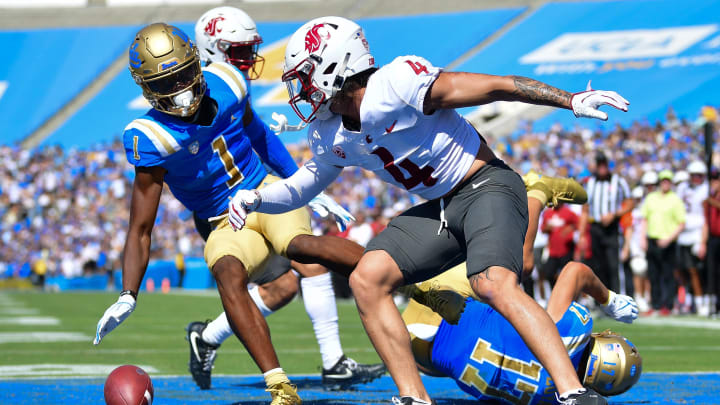 Oct 7, 2023; Pasadena, California, USA; UCLA Bruins linebacker Ale Kaho (1) misses catching a pass against the defense of Washington State Cougars defensive back Kapena Gushiken (4) during the first half at Rose Bowl. Mandatory Credit: Gary A. Vasquez-USA TODAY Sports