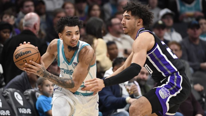 Jan 10, 2024; Charlotte, North Carolina, USA; Charlotte Hornets guard James Bouknight (2) looks to pass as he is defended by Sacramento Kings guard forward Colby Jones (20) during the first half at the Spectrum Center. Mandatory Credit: Sam Sharpe-USA TODAY Sports