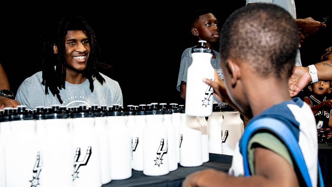 Aug 8, 2026; San Antonio, Texas, USA; San Antonio Spurs center Jayden Quaintance (22) hands out water bottles to families during the team's fifth annual Back to School Bash at Frost Bank Center.