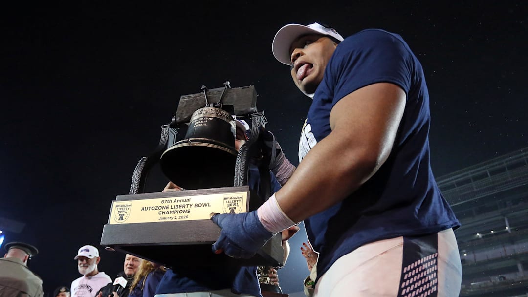 Jan 2, 2026; Memphis, TN, USA; Navy Midshipmen defensive lineman Landon Robinson (96) reacts while holding the Liberty Bowl trophy after defeating the Cincinnati Bearcats in the Liberty Bowl at Simmons Bank Liberty Stadium. Mandatory Credit: Petre Thomas-Imagn Images