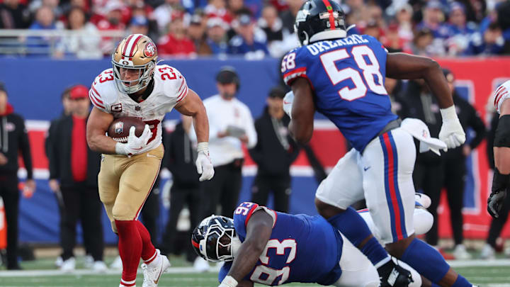 Nov 2, 2025; East Rutherford, New Jersey, USA; San Francisco 49ers running back Christian McCaffrey (23) runs past New York Giants defensive tackle Rakeem Nunez-Roches (93) during the second half at MetLife Stadium. 