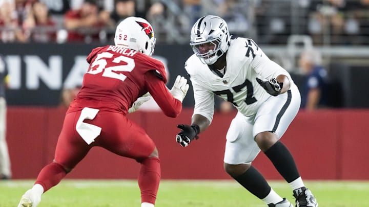 Aug 23, 2025; Glendale, Arizona, USA; Las Vegas Raiders tackle Thayer Munford Jr. (77) against Arizona Cardinals linebacker Jordan Burch (52) during a preseason NFL game at State Farm Stadium. Mandatory Credit: Mark J. Rebilas-Imagn Images