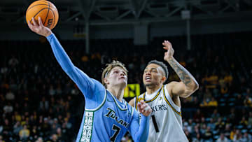 Feb 23, 2025; Wichita, Kansas, USA; Tulane Green Wave guard Rowan Brumbaugh (7) shoots the ball around Wichita State Shockers guard Xavier Bell (1) during the first half at Charles Koch Arena. 