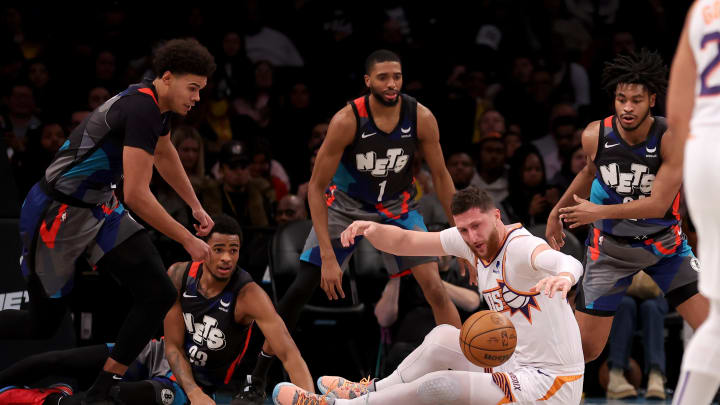 Jan 31, 2024; Brooklyn, New York, USA; Phoenix Suns center Jusuf Nurkic (20) fights for a loose ball against Brooklyn Nets forward Cameron Johnson (2) and center Nic Claxton (33) and forward Mikal Bridges (1) and guard Cam Thomas (24) during the third quarter at Barclays Center. Mandatory Credit: Brad Penner-USA TODAY Sports