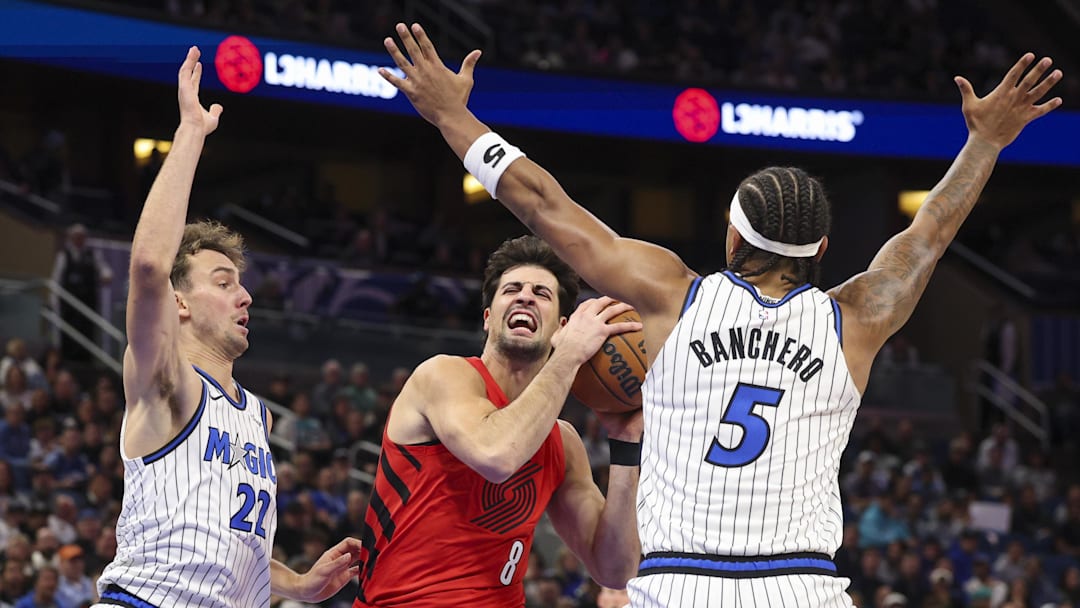 Nov 10, 2025; Orlando, Florida, USA; Portland Trail Blazers forward Deni Avdija (8) drives to the basket past Orlando Magic forward Franz Wagner (22) and forward Paolo Banchero (5) in the first quarter  at Kia Center. Mandatory Credit: Nathan Ray Seebeck-Imagn Images