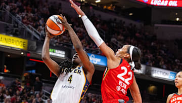 Jun 4, 2023; Indianapolis, Indiana, USA; Indiana Fever center Queen Egbo (4) shoots the ball while Las Vegas Aces forward A'ja Wilson (22) defends in the first half at Gainbridge Fieldhouse. Mandatory Credit: Trevor Ruszkowski-USA TODAY Sports
