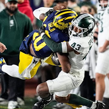 Michigan quarterback Alex Orji (10) is brought down by Michigan State defensive back Malik Spencer (43) during the second half at Michigan Stadium in Ann Arbor on Saturday, Oct. 26, 2024.