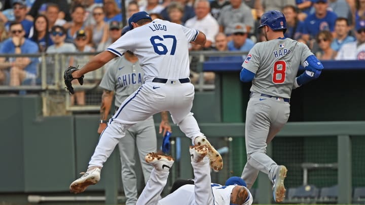 Jul 27, 2024; Kansas City, Missouri, USA; Kansas City Royals first baseman Salvador Perez (13) dives to first base to force out Chicago Cubs left fielder Ian Happ (8), as pitcher Seth Lugo (67) leaps over him in the first inning at Kauffman Stadium. Mandatory Credit: Peter Aiken-USA TODAY Sports