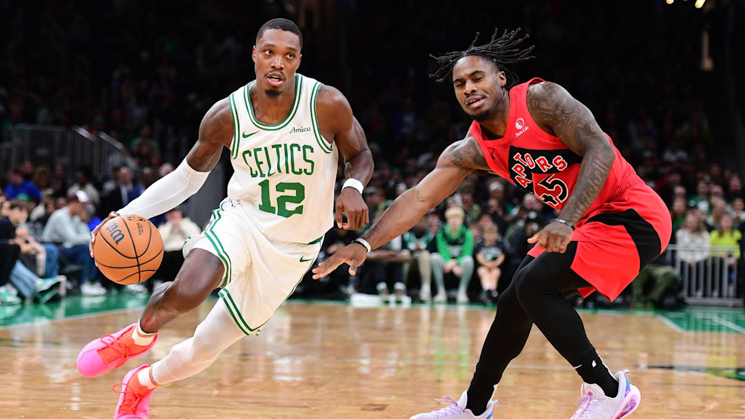Oct 13, 2024; Boston, Massachusetts, USA; Boston Celtics guard Lonnie Walker IV (12) controls the ball while Toronto Raptors guard Davion Mitchell (45) defends during the first half at TD Garden. Mandatory Credit: Bob DeChiara-Imagn Images