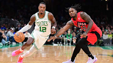 Oct 13, 2024; Boston, Massachusetts, USA;  Boston Celtics guard Lonnie Walker IV (12) controls the ball while Toronto Raptors guard Davion Mitchell (45) defends during the first half at TD Garden. Mandatory Credit: Bob DeChiara-Imagn Images