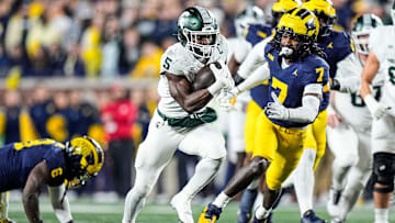 Michigan State running back Nate Carter (5) runs against Michigan defensive back Makari Paige (7) during the first half at Michigan Stadium in Ann Arbor on Saturday, Oct. 26, 2024.