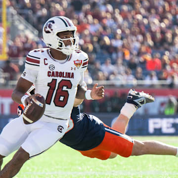 Dec 31, 2024; Orlando, FL, USA; South Carolina Gamecocks quarterback LaNorris Sellers (16) runs the ball against Illinois Fighting Illini linebacker Joe Barna (43) in the first quarter at Camping World Stadium. Mandatory Credit: Jeremy Reper-Imagn Images