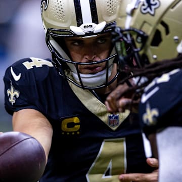 Sep 8, 2024; New Orleans, Louisiana, USA;  New Orleans Saints quarterback Derek Carr (4) hands off to running back Alvin Kamara (41) against the Carolina Panthers during the pregame at Caesars Superdome. Mandatory Credit: Stephen Lew-Imagn Images