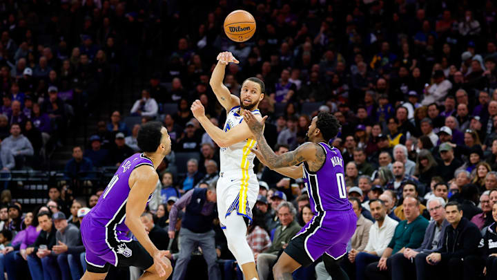 Jan 22, 2025; Sacramento, California, USA; Golden State Warriors guard Stephen Curry (30) passes the ball against Sacramento Kings guard Malik Monk (0) and forward Trey Lyles (41) during the fourth quarter at Golden 1 Center. Mandatory Credit: Sergio Estrada-Imagn Images