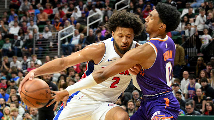 Oct 8, 2024; East Lansing, Michigan, USA;  Detroit Pistons guard Cade Cunningham (2) keeps the ball away from Phoenix Suns forward Ryan Dunn (0): Dale Young-Imagn Images