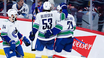 Jan 14, 2025; Winnipeg, Manitoba, CAN;  Vancouver Canucks forward Nils Hoglander (21) celebrates with forward Teddy Blueger (53) after scoring a goal against the Winnipeg Jets during the third period at Canada Life Centre. Mandatory Credit: Terrence Lee-Imagn Images