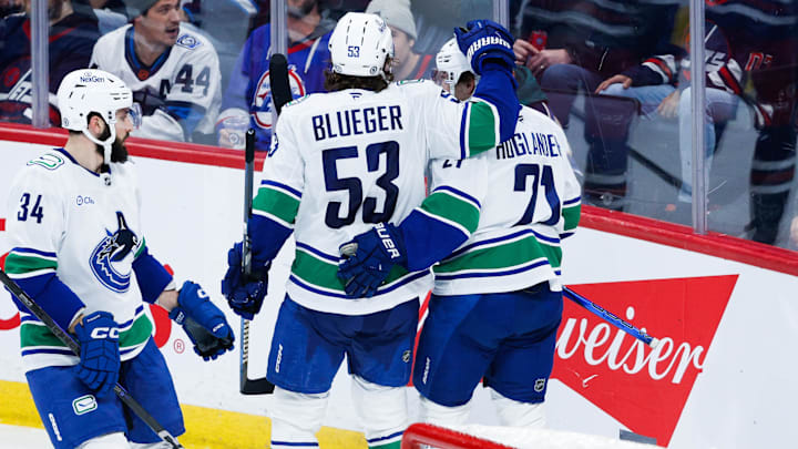 Jan 14, 2025; Winnipeg, Manitoba, CAN;  Vancouver Canucks forward Nils Hoglander (21) celebrates with forward Teddy Blueger (53) after scoring a goal against the Winnipeg Jets during the third period at Canada Life Centre. Mandatory Credit: Terrence Lee-Imagn Images