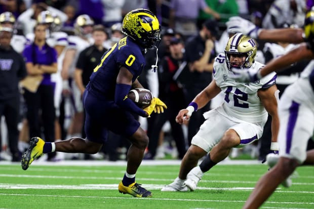 Michigan Wolverines defensive back Mike Sainristil runs back an interception during the 2023 CFP national championship game