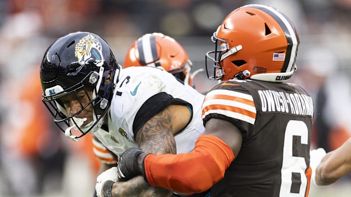 Dec 10, 2023; Cleveland, Ohio, USA; Jacksonville Jaguars tight end Evan Engram (17) is tackled by Cleveland Browns linebacker Jeremiah Owusu-Koramoah (6) as he runs the ball during the fourth quarter at Cleveland Browns Stadium. Mandatory Credit: Scott Galvin-Imagn Images