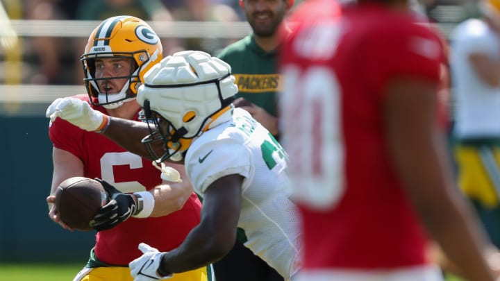 Green Bay Packers quarterback Sean Clifford (6) hands the ball to running back Emanuel Wilson at training camp on Aug. 14.