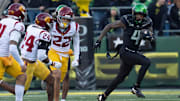 Oregon’s Malik Benson, right, breaks the USC coverage on a punt return for a touchdown.